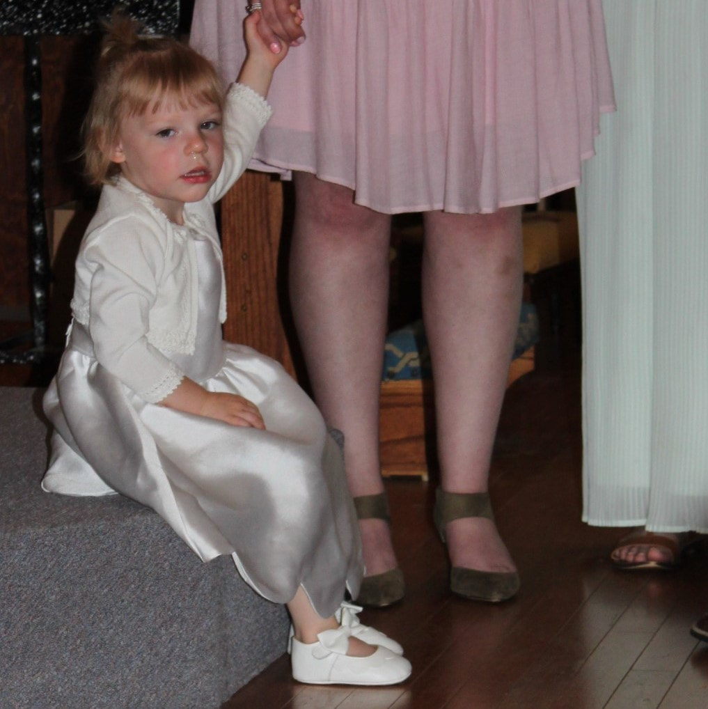little girl in white dress sitting inside church